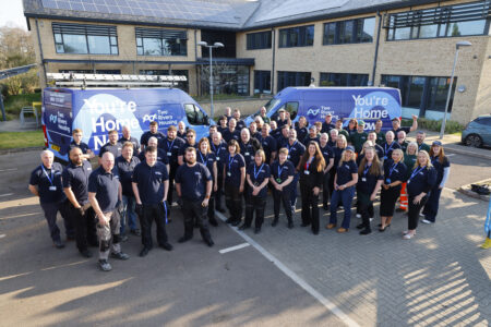Group shot of the Two Rivers Housing repairs and maintenance teams in front of their newly branded vans. The brands feature the new Two Rivers Housing logo and the strap line 'You're Home Now.